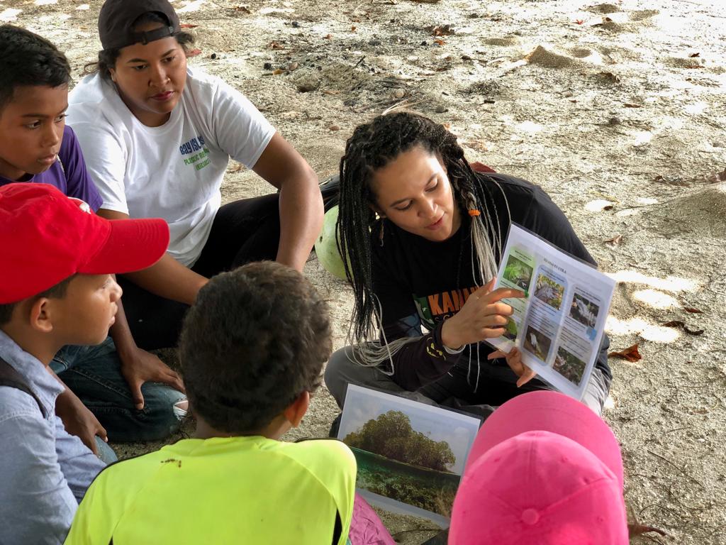 Environmental Educator Daniela Sansur explains to School of Nature Students the differences between the 3 Iguana species found on Utila